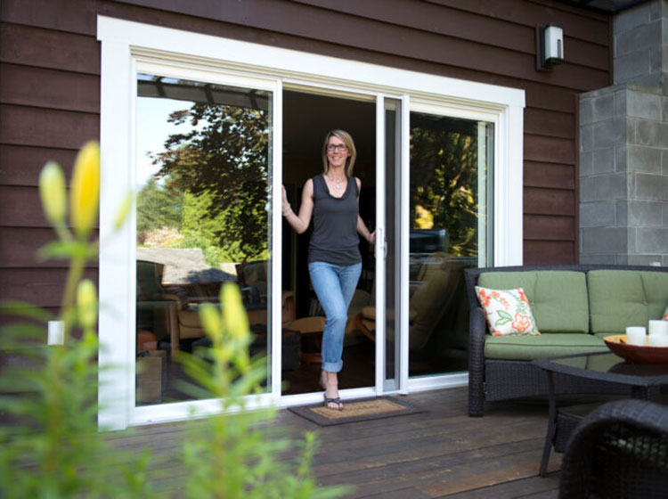 Woman at sliding patio door with retractable screen